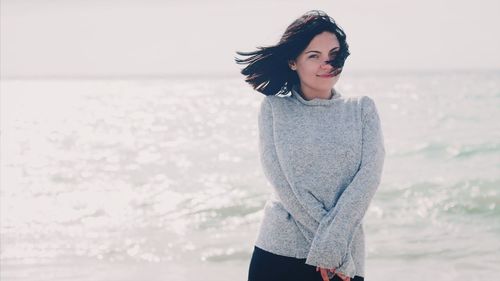 Portrait of woman standing against sea