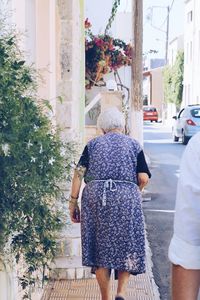 Rear view of friends standing against plants