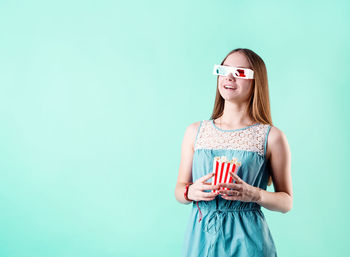 Portrait of a smiling young woman against blue background