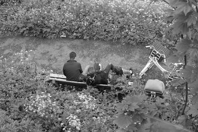 Men sitting on field against trees