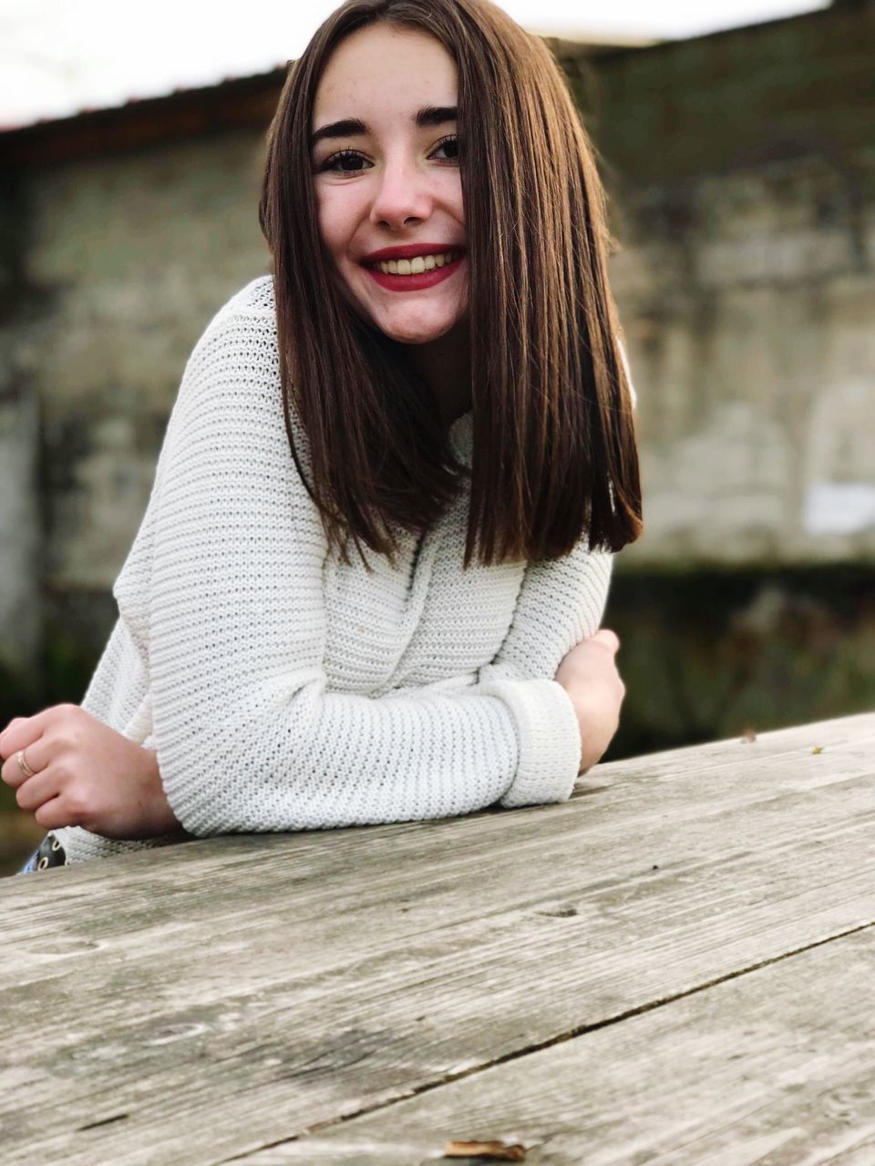 looking at camera, real people, one person, smiling, portrait, long hair, young adult, day, front view, focus on foreground, young women, wood - material, leisure activity, happiness, lifestyles, beautiful woman, outdoors, close-up