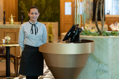 Portrait of receptionist standing in hotel