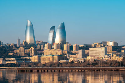 Buildings in city against clear sky