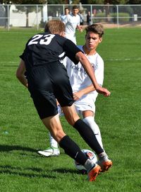 Full length of siblings playing on soccer field