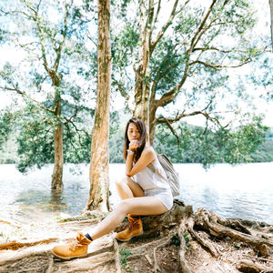 Young woman sitting on lakeshore