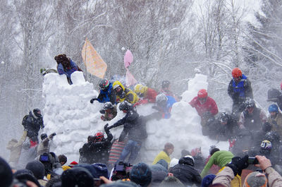 A group of people storming the snow fortress during traditional maslenitsa festivities in russia
