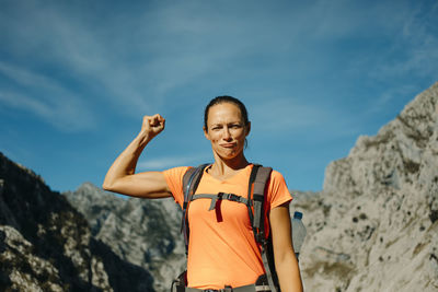 Portrait of smiling young woman standing against sky