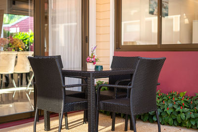 Empty chairs and table by window at home