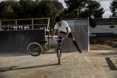 Young man doing stunt with bicycle at bike park