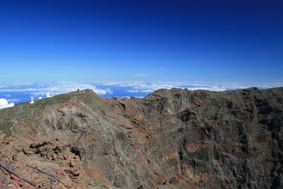 Scenic view of rocky mountains against blue sky