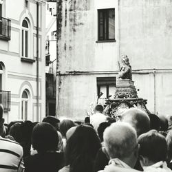 People on street against buildings in city