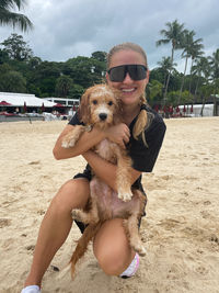 Woman holding a do at the beach