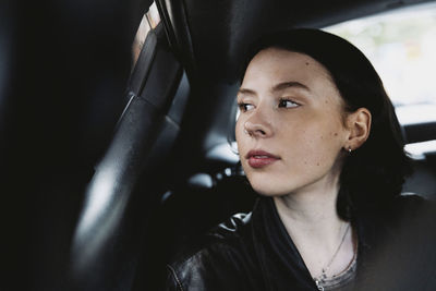 Female tourist looking through window while traveling car