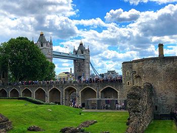 View of arch bridge and buildings against cloudy sky