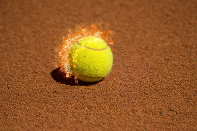 Close-up of tennis ball burning on table