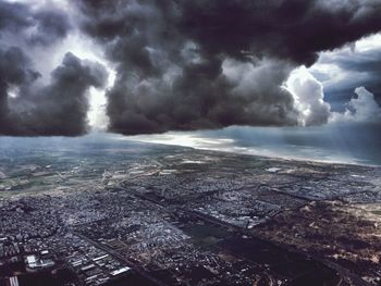 Aerial view of city against cloudy sky