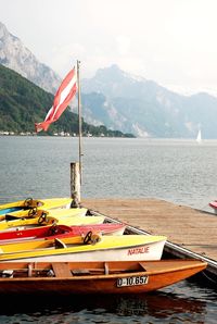 Boat moored on lake against sky