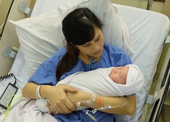 Mother looking at daughter in hospital ward
