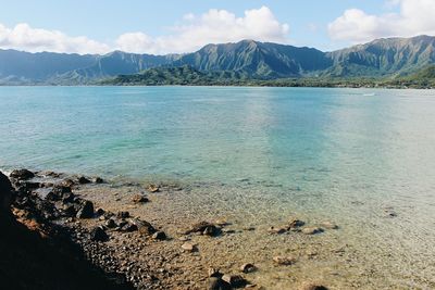 Scenic view of sea and mountains against sky