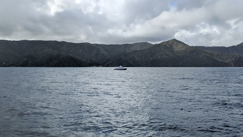 Scenic view of sea and mountains against sky