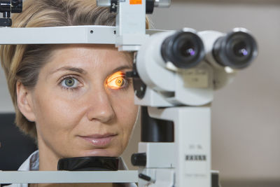 Close-up portrait of woman with camera