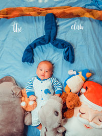 Portrait of cute baby boy lying down on bed