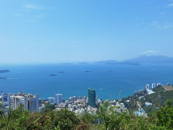 High angle view of city by sea against sky