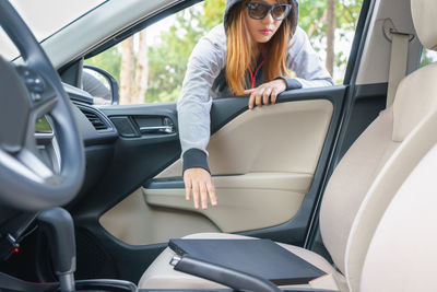 Young woman picking up file from car