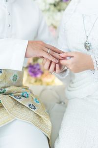 Midsection of bridegroom during ring ceremony