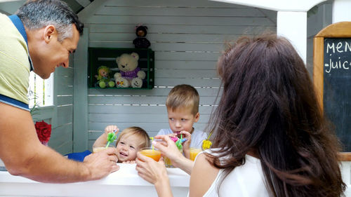 Summer, in the garden, parents, mom and dad, carry freshly squeezed fruit juice to treat their