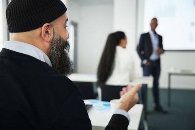 Businessman asking questions during presentation