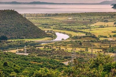 High angle view of river amidst field against sky