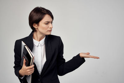 Young woman looking away against white background