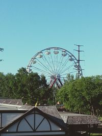 Low angle view of ferris wheel against blue sky