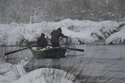 Fishermen fishing in lake during winter