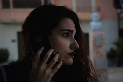 Close-up of young woman looking away while talking on smart phone