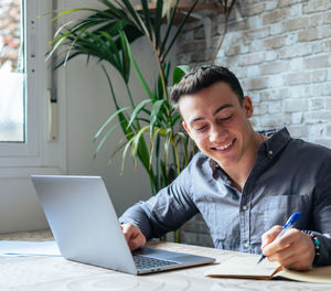 Portrait of man using laptop at office