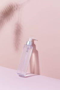 A mock-up of a cosmetic product on a pink background with shadows. cleansing tonic for the face,