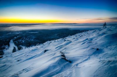 Scenic view of snowcapped mountain against sky during sunset