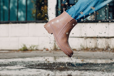 Low section of woman standing in puddle