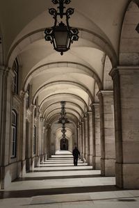 Rear view of man walking in corridor of building