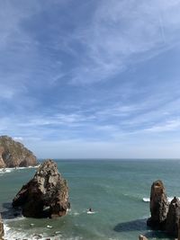 Rocks in sea against sky