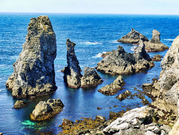 Panoramic view of rocks on beach against sky