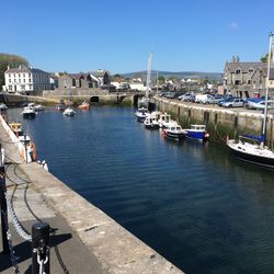 Boats moored in river against buildings in city