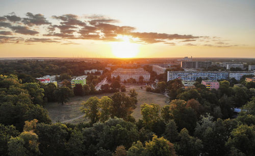 High angle view of trees and buildings against sky during sunset