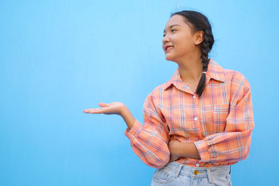 Woman standing against blue background