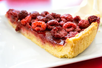 Close-up of raspberry tart slice served in plate