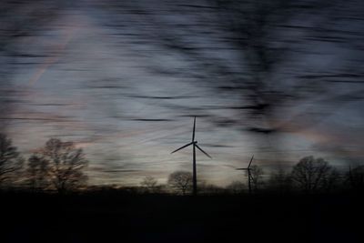 Low angle view of wind turbines at sunset