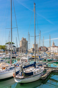 Sailboats moored at harbor