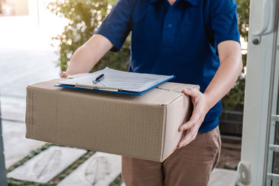 Midsection of man holding camera in box